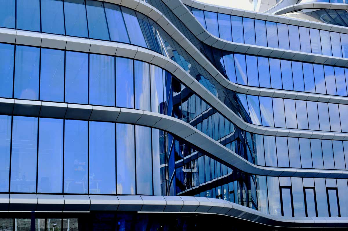 Close view of the laminated curved glass edge and panel bonding on the MOL Campus building